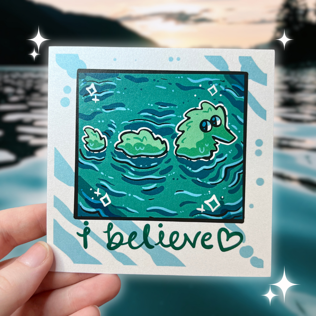 A print that looks like a camera photo, hand written text at the bottom that says "i believe <3", in the photo is lake water with a fuzzy worm lochness monster