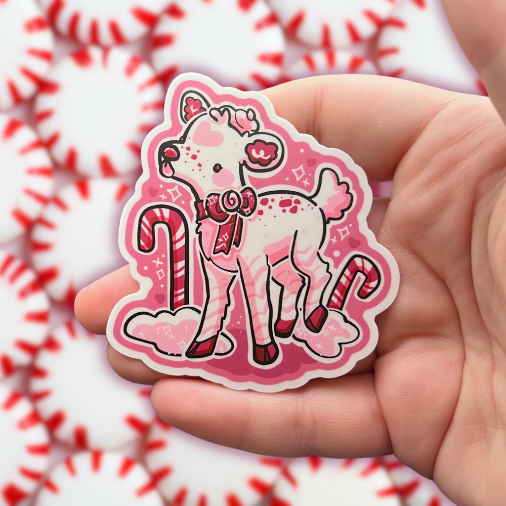 A sticker of a white deer that has pink and red accents and is peppermint themed