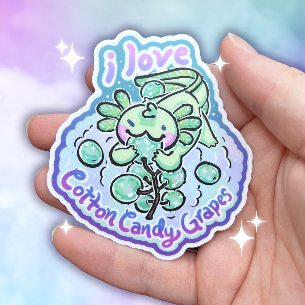 A sticker of a light teal axolotl chomping on some cotton candy grapes, while also floating on a huge pile of them, and text that says "i love cotton candy grapes"