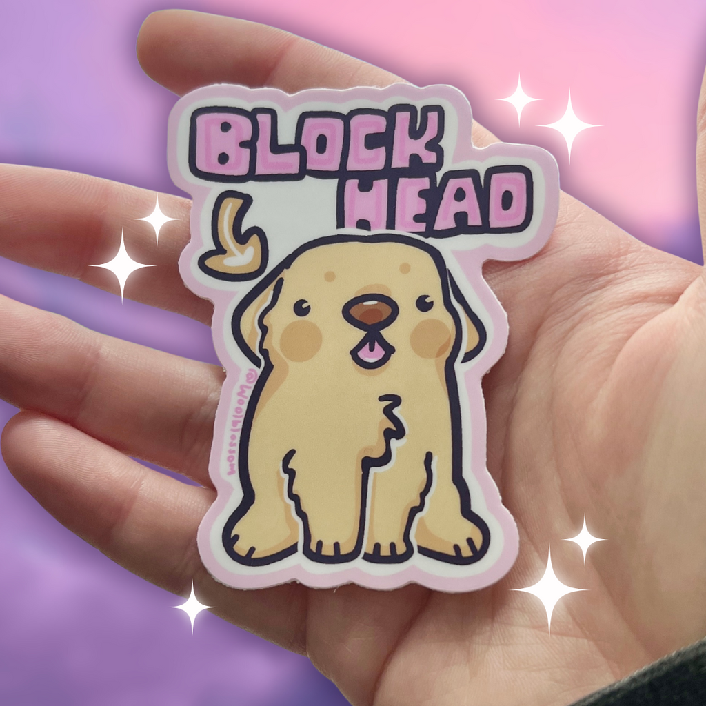 Hand holding a sticker with a cartoon dog and 'Block Head' text