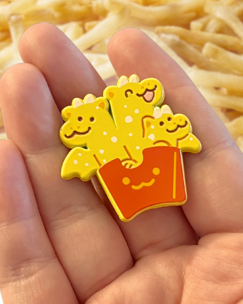 french fry dragon pin held in a hand