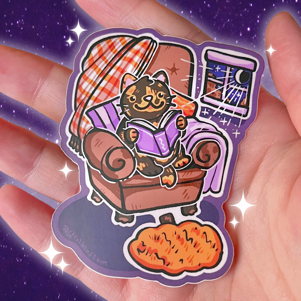 Sticker of a cat reading in a chair on a hand with a purple background
