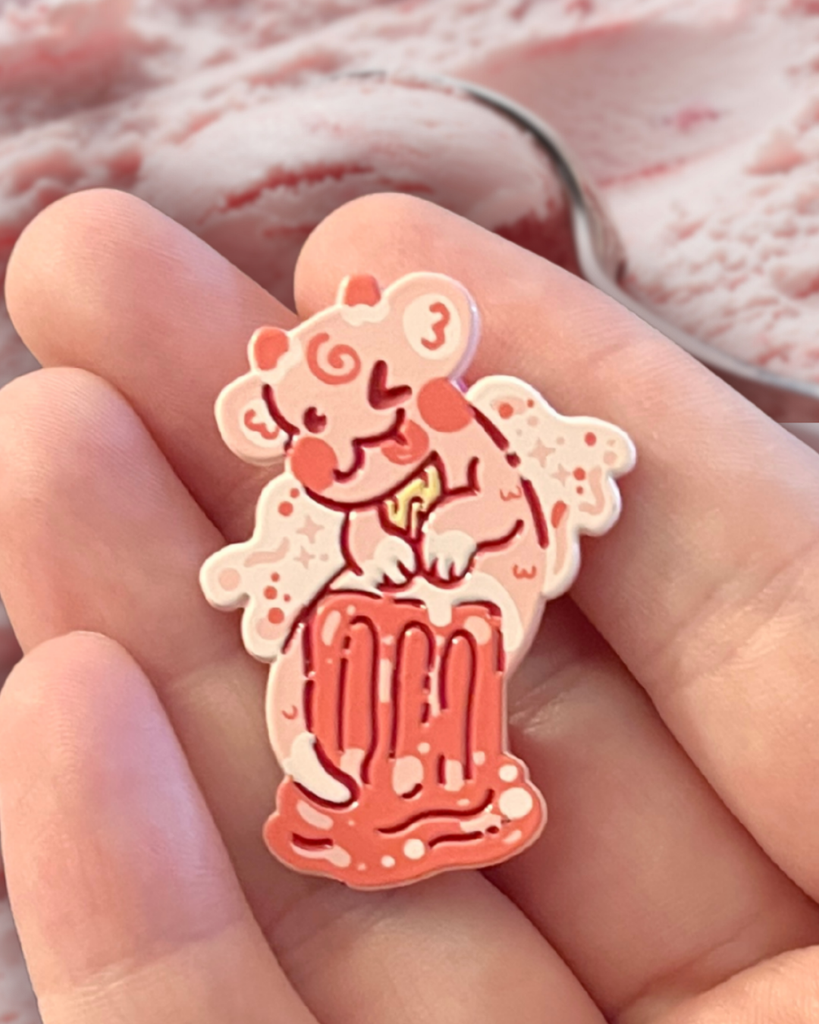 strawberry creamsicle dragon pin held in a hand