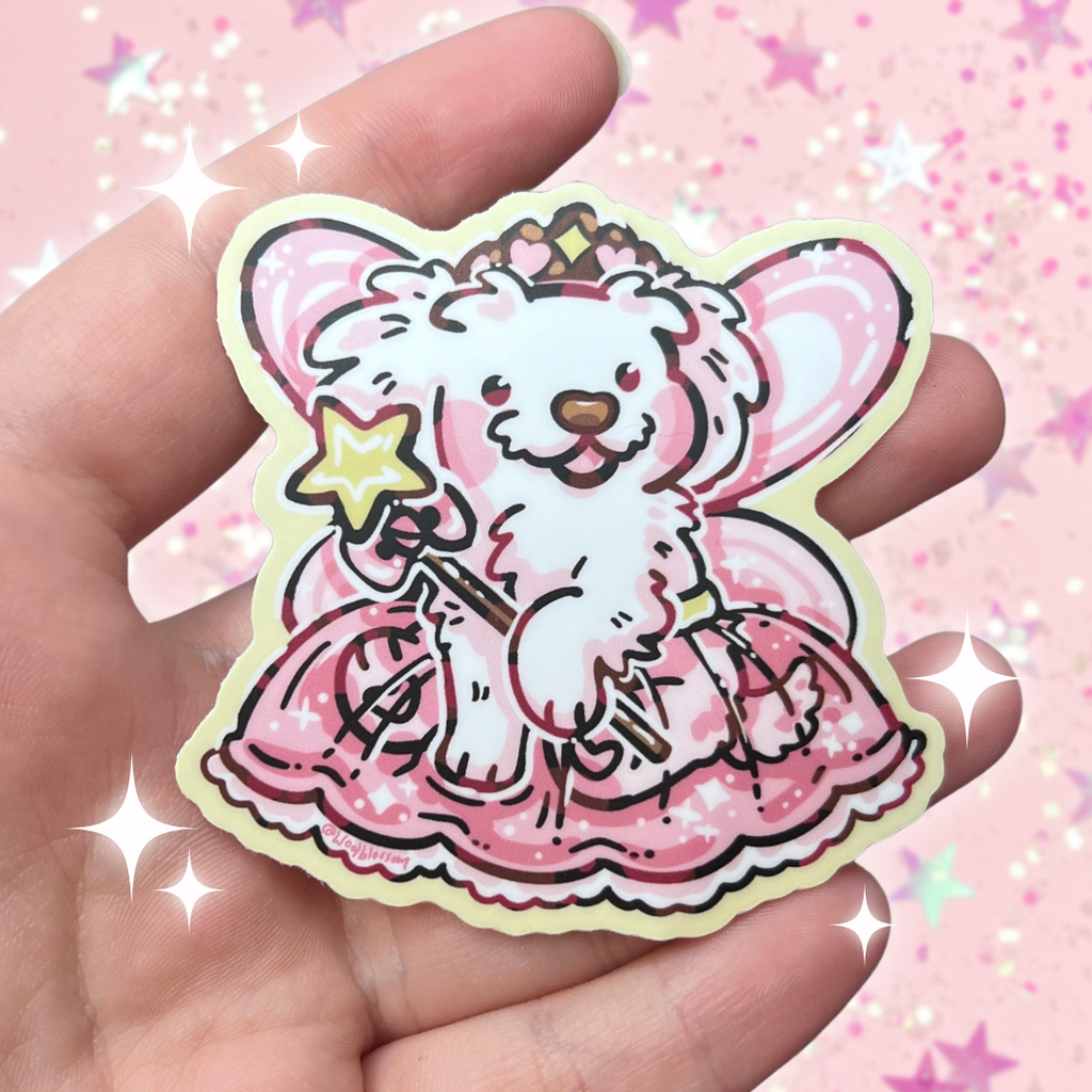 A sticker of a white puppy with fairy wings, star wand, tutu, and princess crown