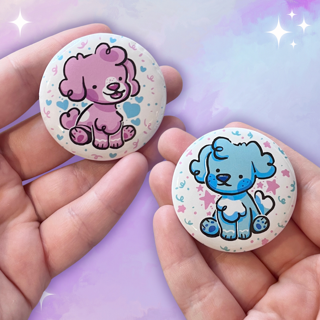 Two buttons, one is pearl a pink puppy sitting happily, the second is sky the blue puppy sitting sweetly. Both buttons are white with blue and pink details