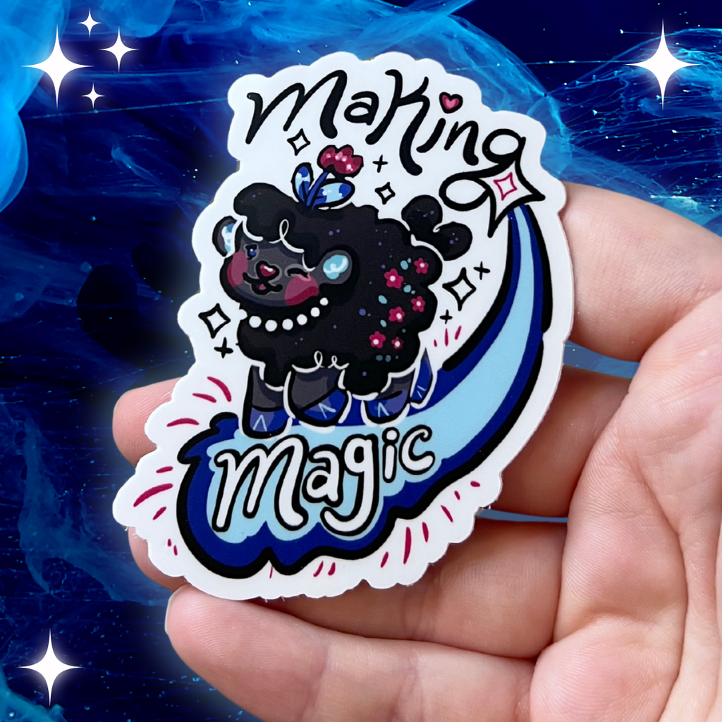 A sticker of a dark grey sheep standing on the tail of a shooting star with the text "making magic"