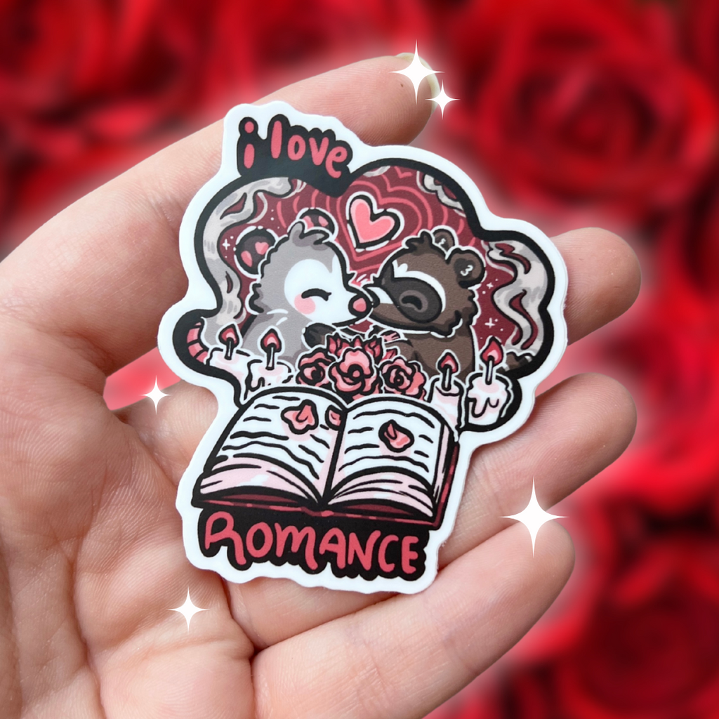 A book genre inspired sticker that says "I love romance" and feature an opossum and raccoon kissing