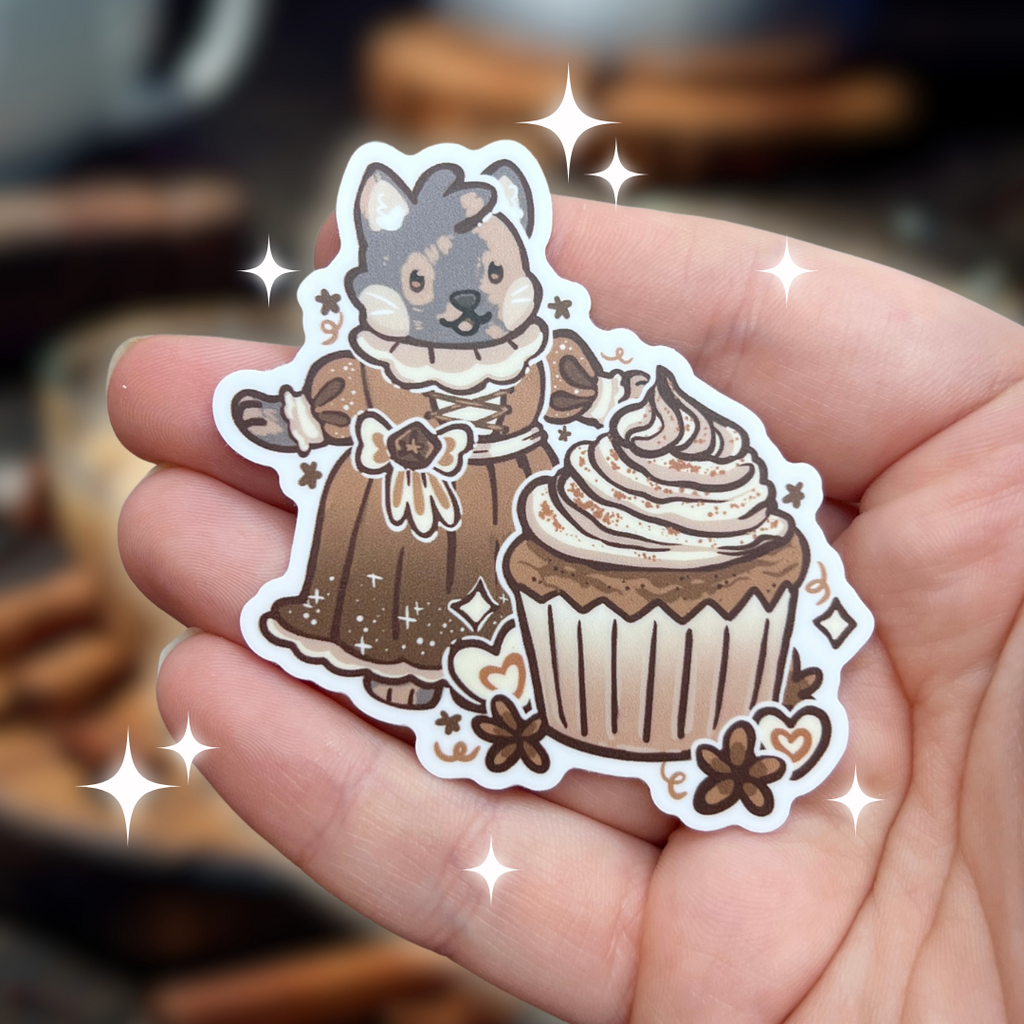 A sticker of my cat Chai dressed in a renaissance/victorian dress, in front of a chai cupcake, and anisse themed