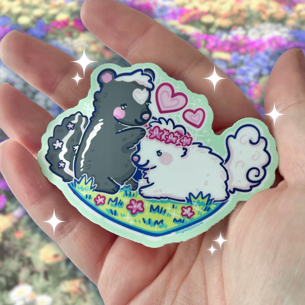 a sticker of Two skunks, one black and one white, on a patch of grass with the black putting a flower crown on the other