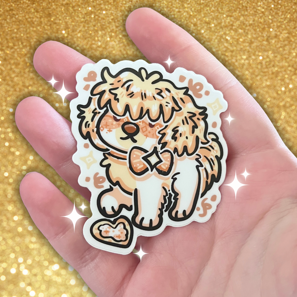 sticker of a pale yellow puppy with a cookie