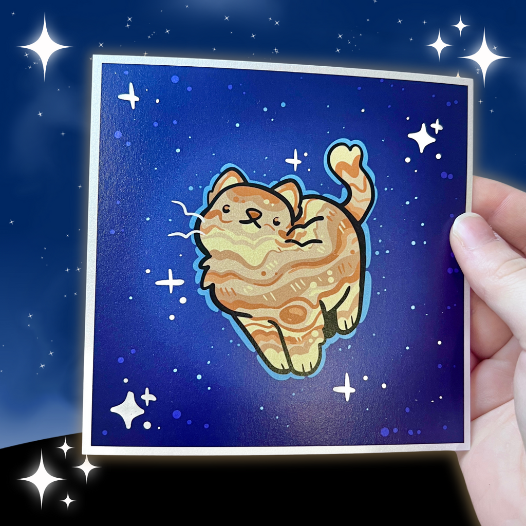 a print of an orange cat with markings like jupiter's on a dark blue background mimicking space