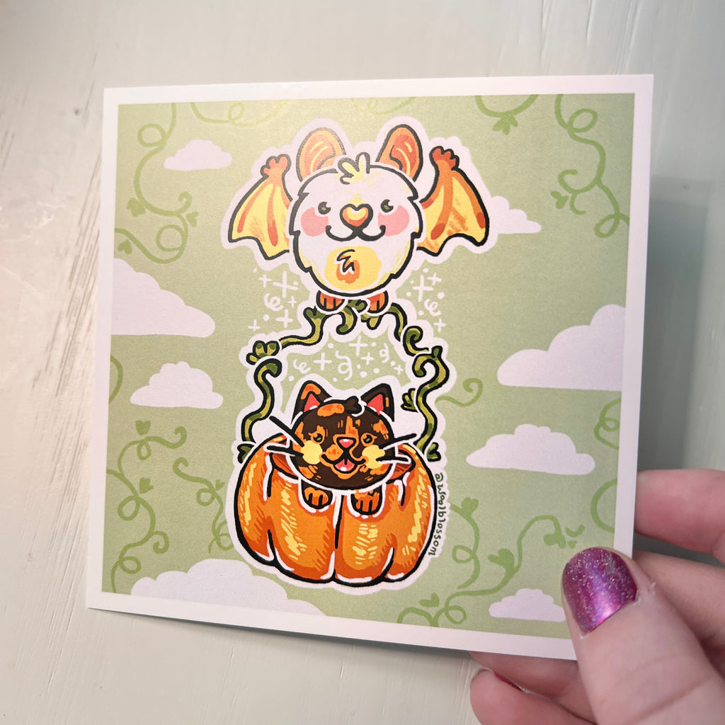 Print with cartoon cat in a pumpkin and bat on a green background held by hand