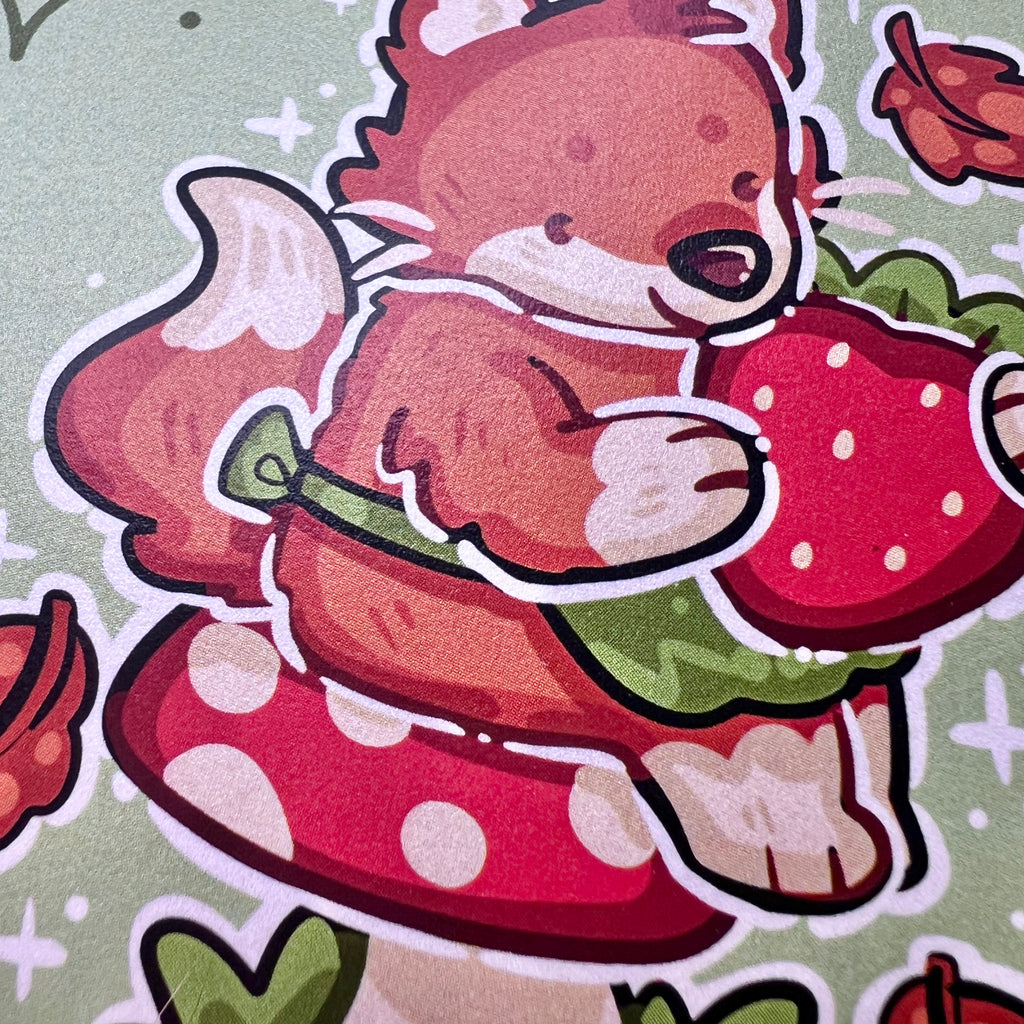 A print of a red fox with a little green apron sitting on a red mushroom, holding a strawberry with autumn leaves falling