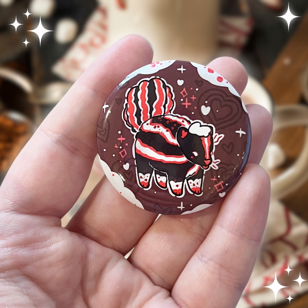 A button of a mostly normal skunk with red accents and chocolate spots, in front of a chocolate background