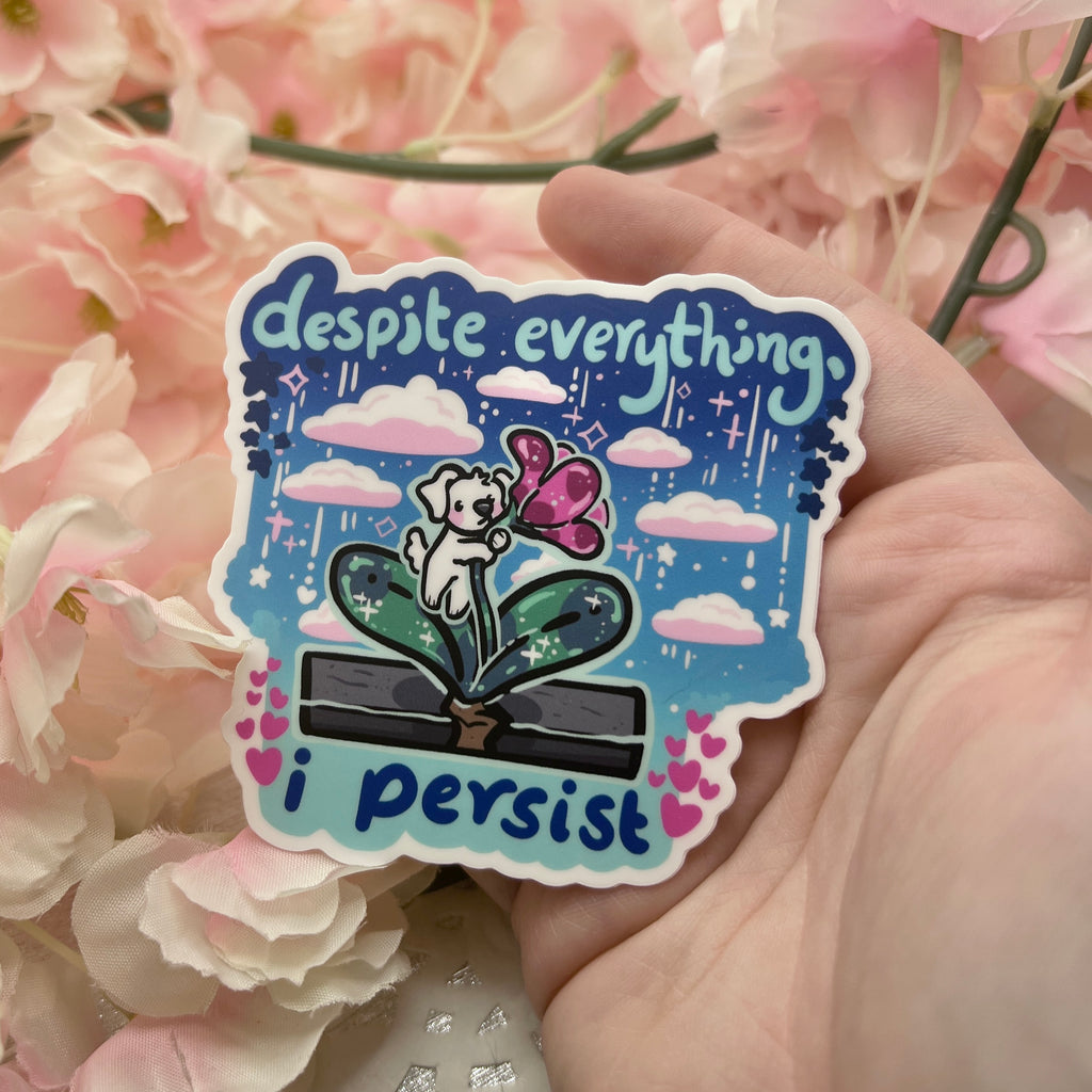 a sticker of a puppy on a flower growing through sidewalk with text that says "despite everything, I persist"