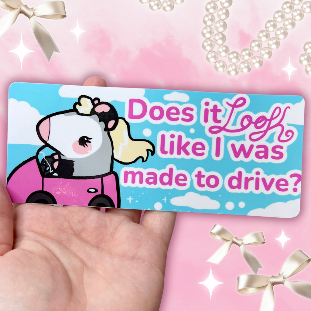 A bumper sticker of a blonde feminine opossum driving with text that says "does it look like I was made to drive"