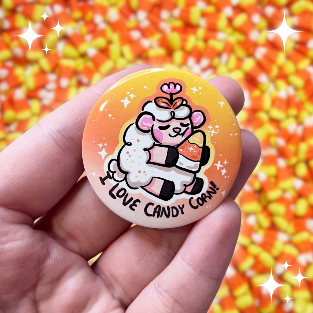 A button of a sheep holding a candy corn, looking content, with the text "I love candy corn!"