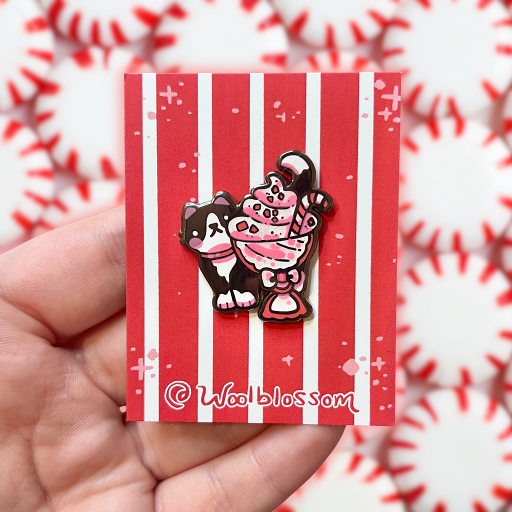 Enamel pin of a black tuxedo peeking out from a peppermint sundae