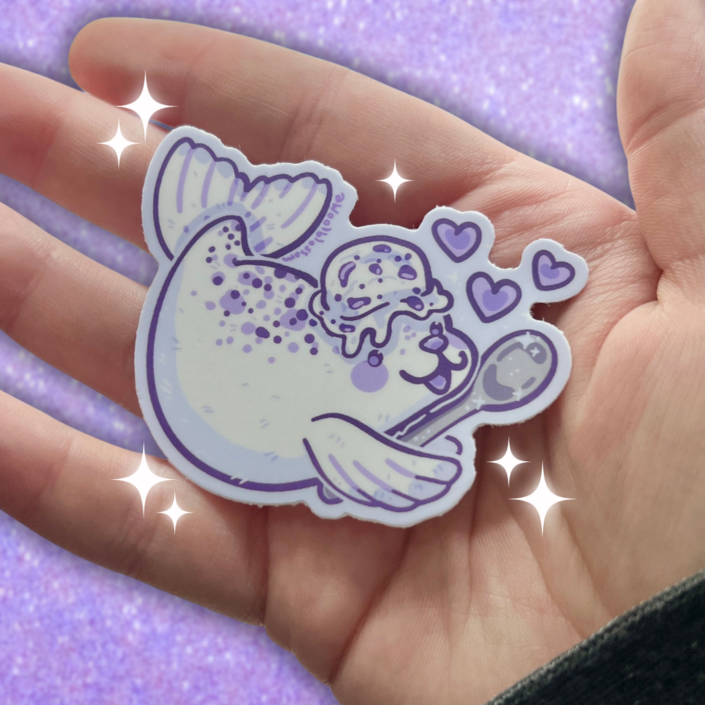 Hand holding a sticker of a cookies and cream seal 