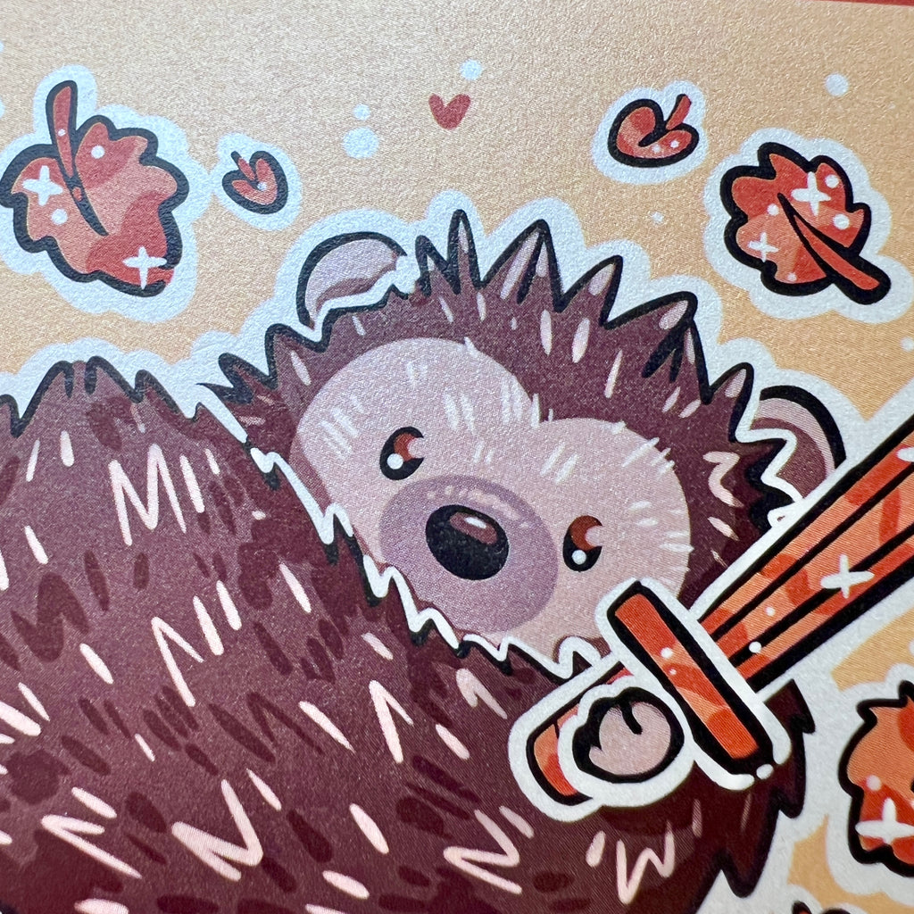 A print of a hedgedhog holding a sword with orange leaves falling around him