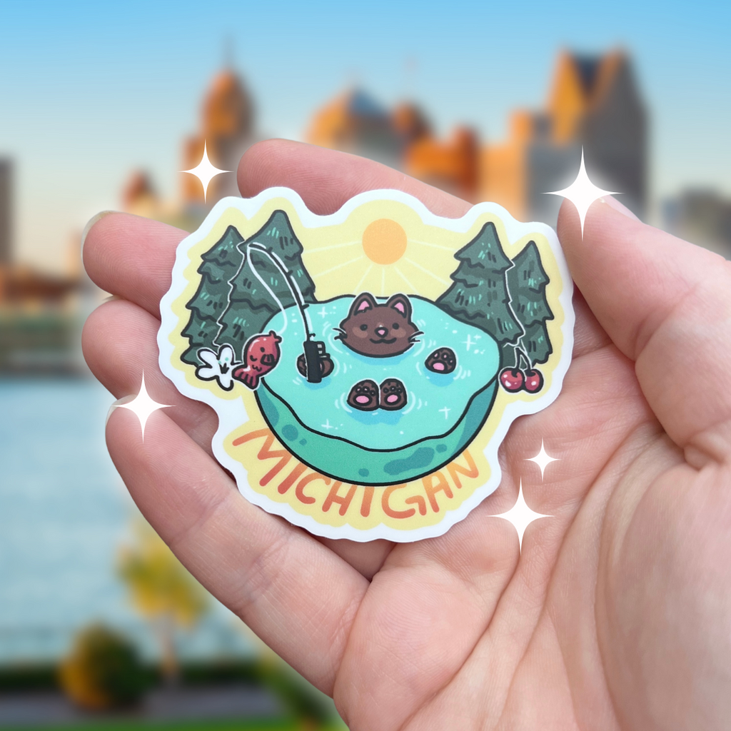 A sticker of a cat sitting in a lake with a fishing pole and the word "michigan"