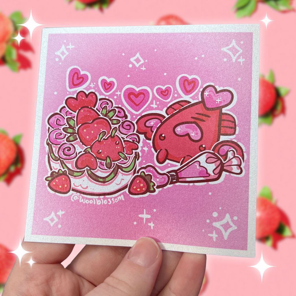 A print of Ruby the love-ster with a cake that has a lobster made of strawberries on top