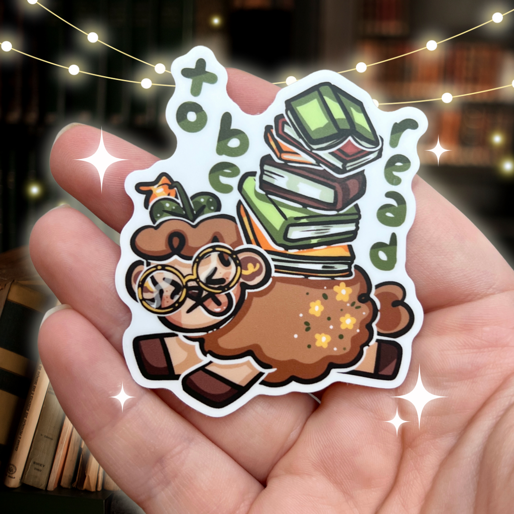 A sticker of Sage the sheep being crushed by a pile of unread books, with text that says " to be read"