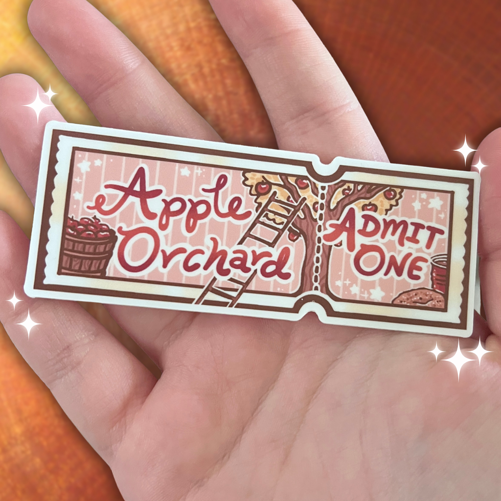 Hand holding a 'Apple Orchard Admit One' ticket design