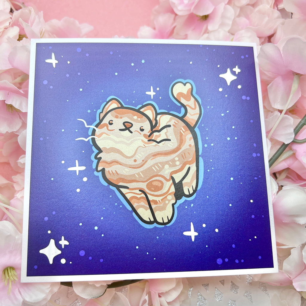 a print of an orange cat with markings like jupiter's on a dark blue background mimicking space