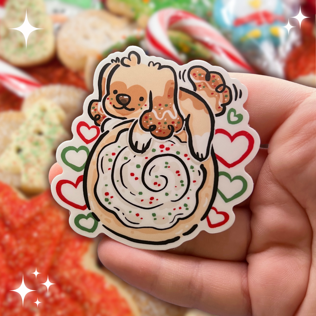 A sticker of a puppy on top of a sugar cookie with white, green, and red accents