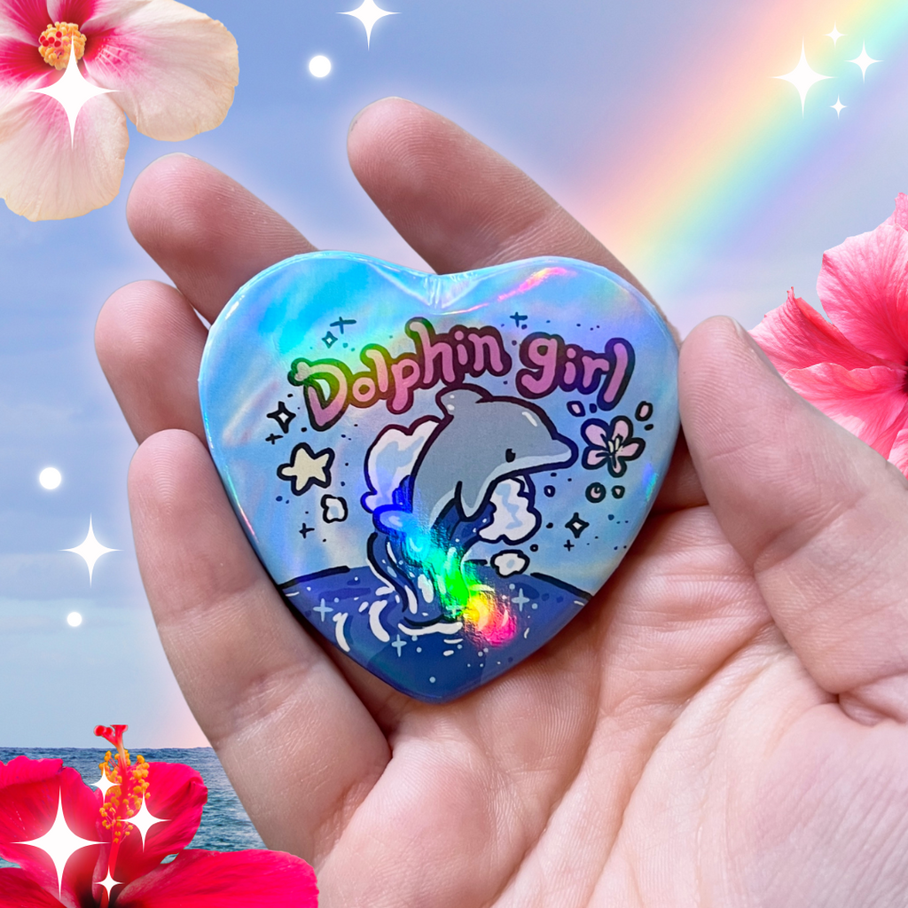 a heart button that says dolphin girl with a dolphin jumping out of the ocean