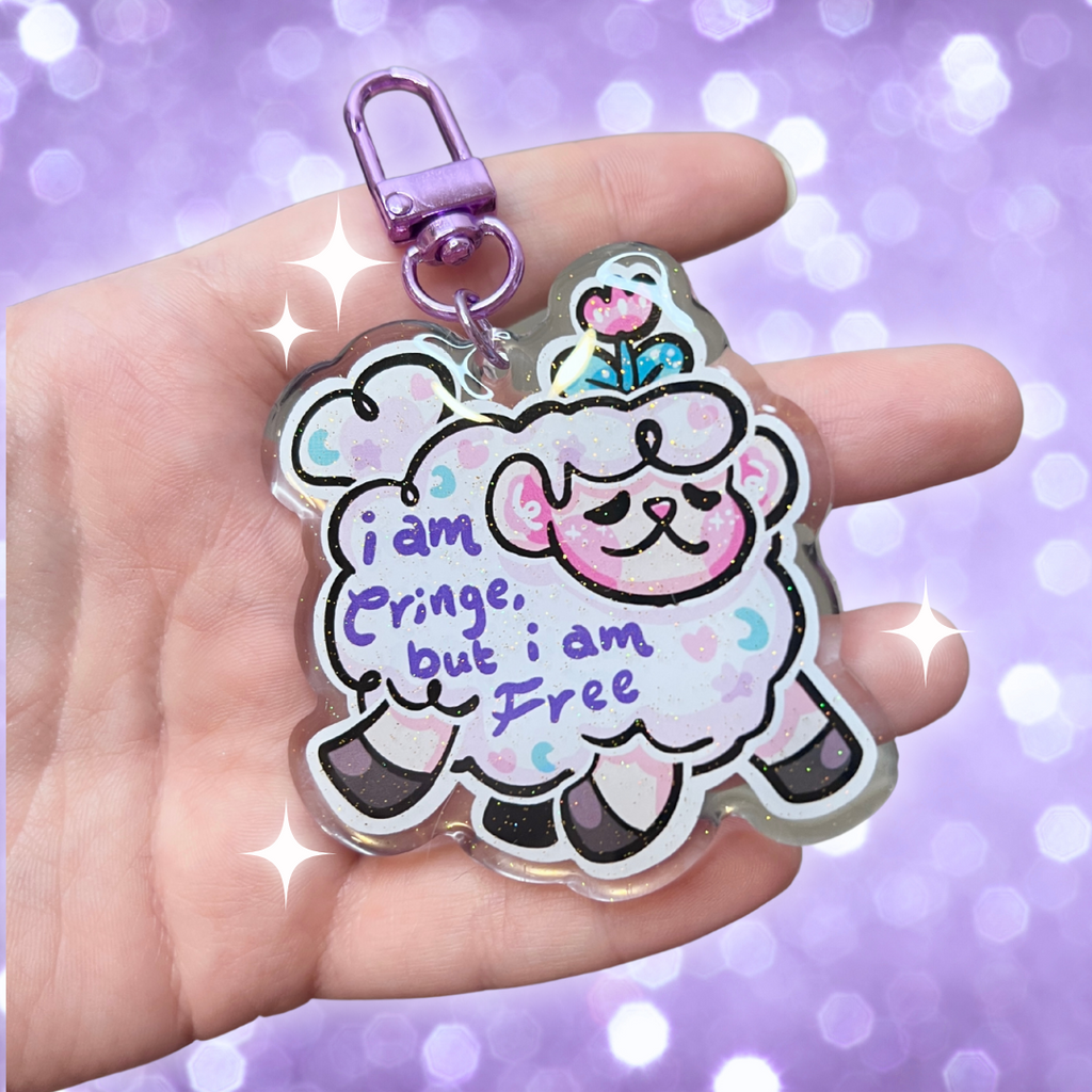 A keychain of sprout the flower sheep mid gallop, with purple text on their wool that says "i am cringe, but i am free"