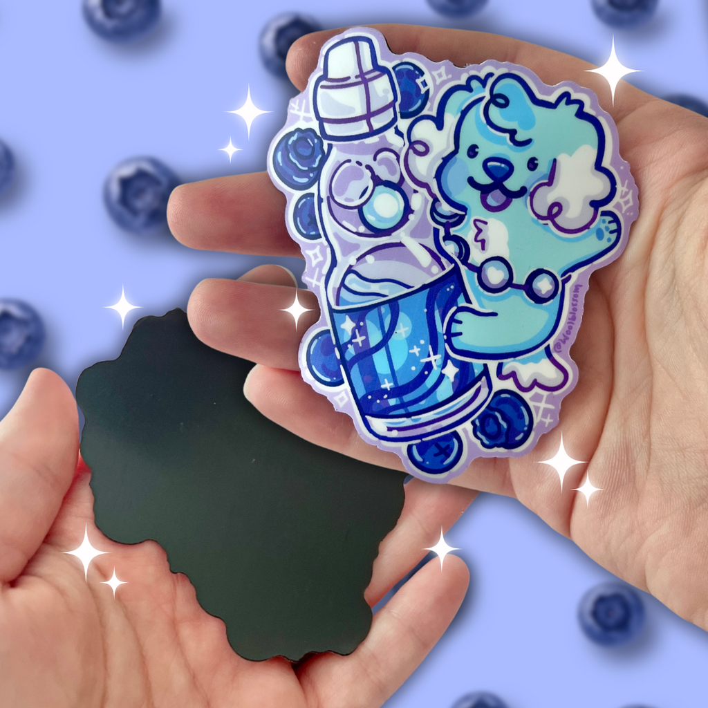 A magnet of a blueberry Japanese soda, with a teal puppy on top and blueberries around them