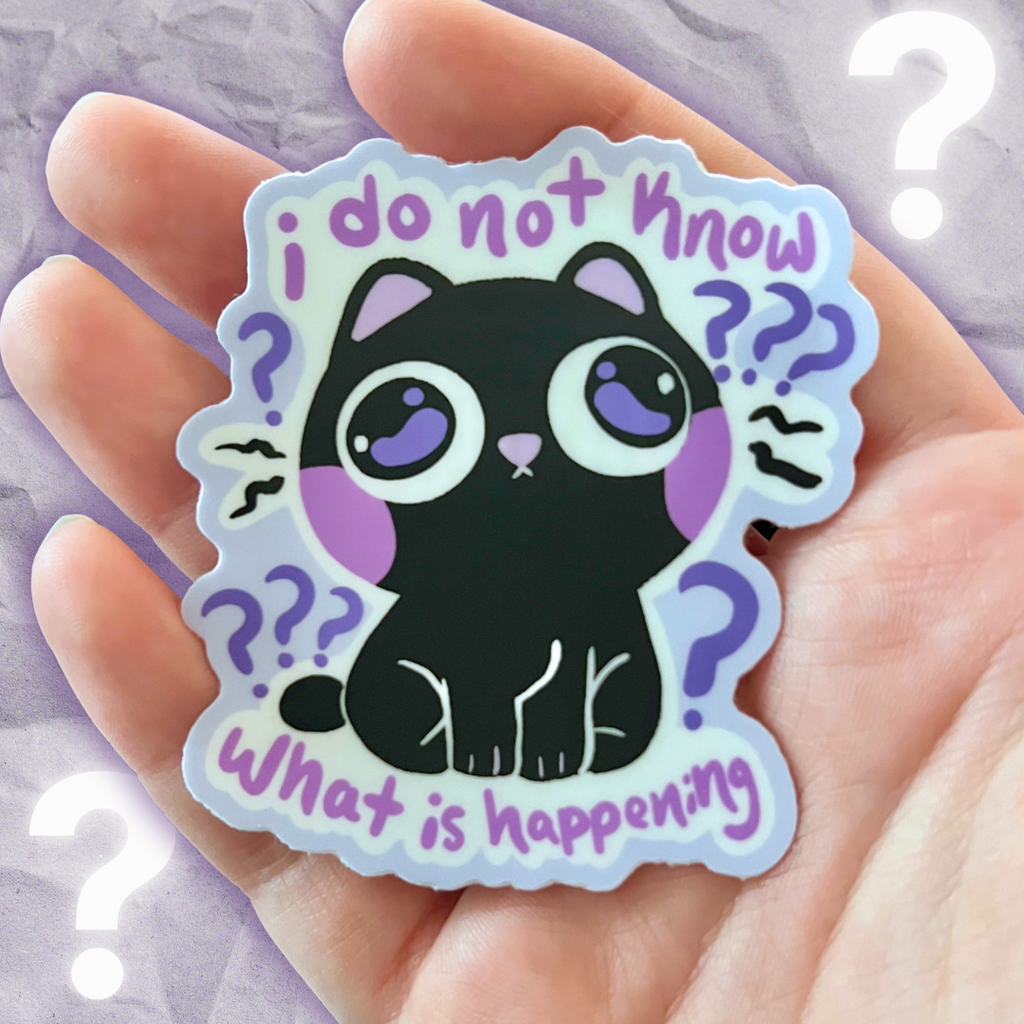 Sticker with a black cat illustration that says "i do not know what is happening"  held in a hand against a light purple background.