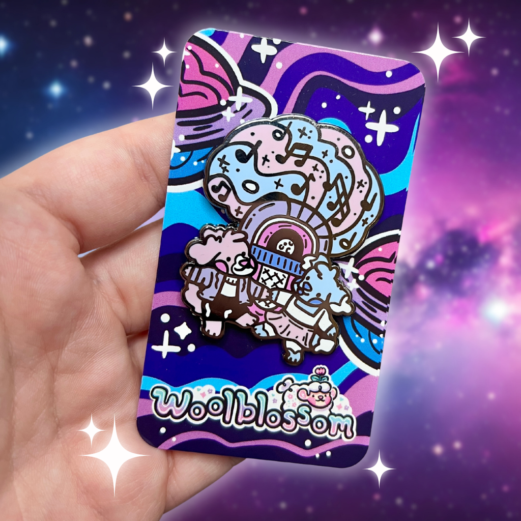 An enamel pin of Pearl the pink puppy and Sky the blue puppy dancing in front of a moon themed jukebox, with blue/pink/purple color scheme