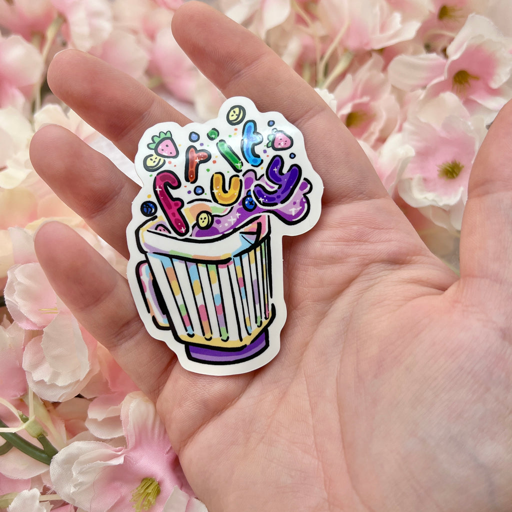 A sticker of a blender with fruit floating out and bubble rainbow text that says "fruity"