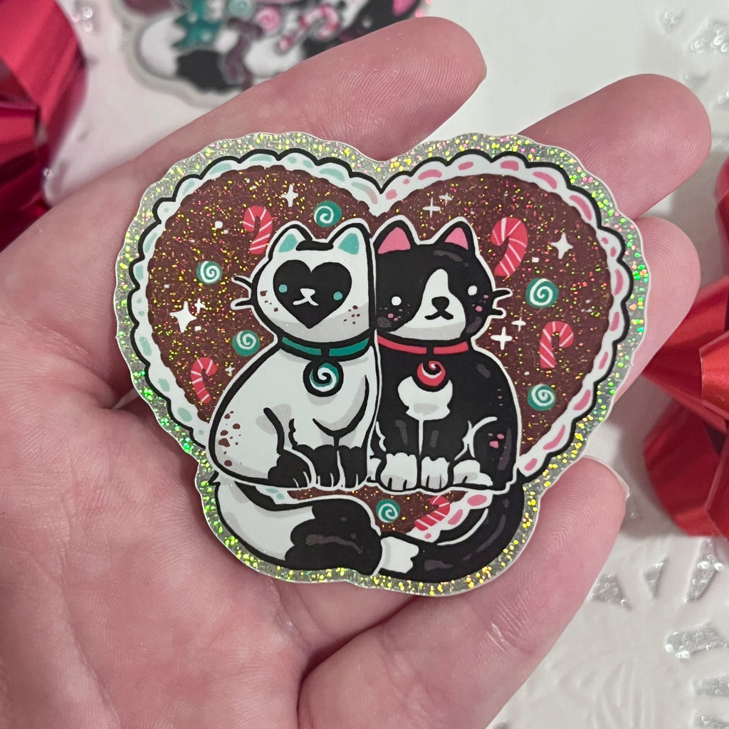 A sticker of two cats, one tuxedo, and one white with black markings, both are mint themed.