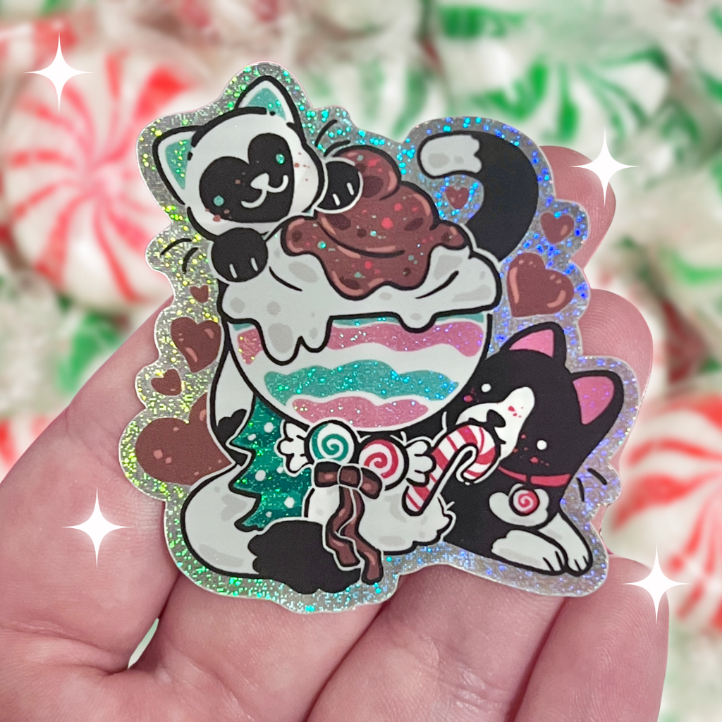 A sticker of two cats, one tuxedo, and one white with black markings, both are mint themed and eating a mint sundae