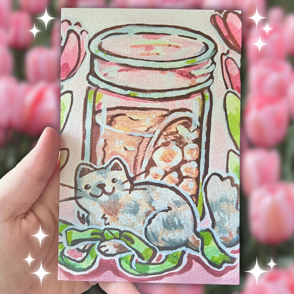 Illustrated card with a cat inside a jar, held by a hand with pink tulips in the background.
