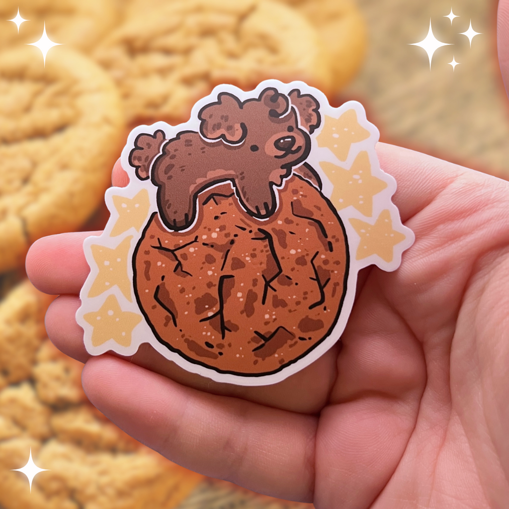 A sticker of a brown puppy on top of a ginger snap cookie with yellow stars