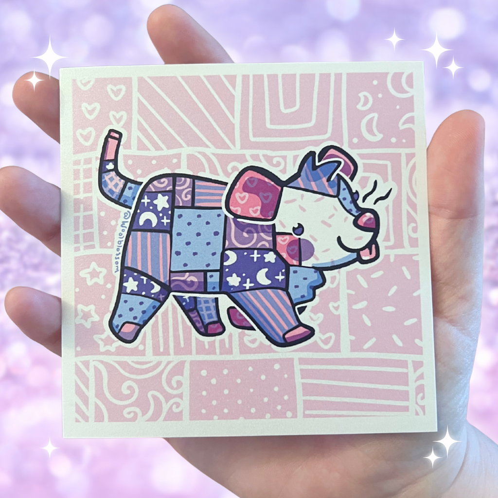 Hand holding a print with a colorful elephant opossum made of patchwork pieces on a patterned background
