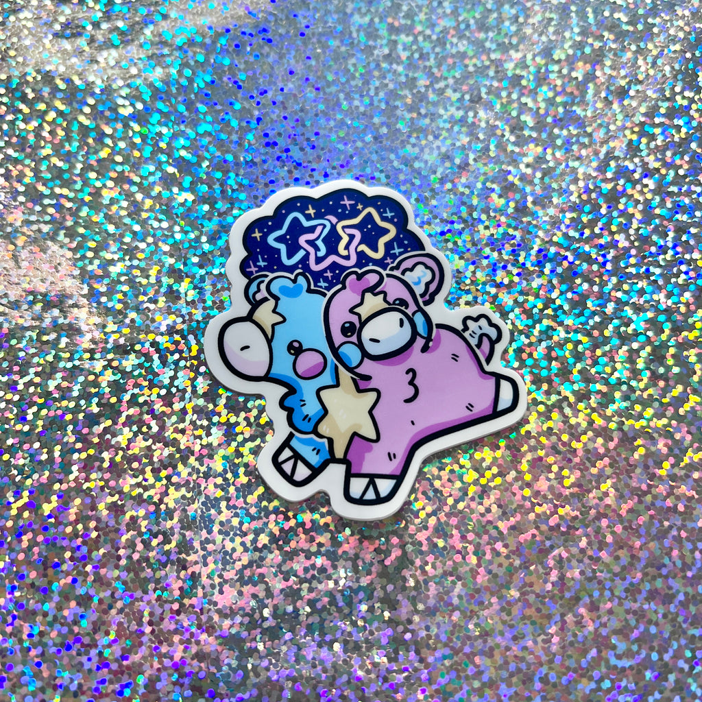 a sticker of a pink and blue two headed calf on a glittery background