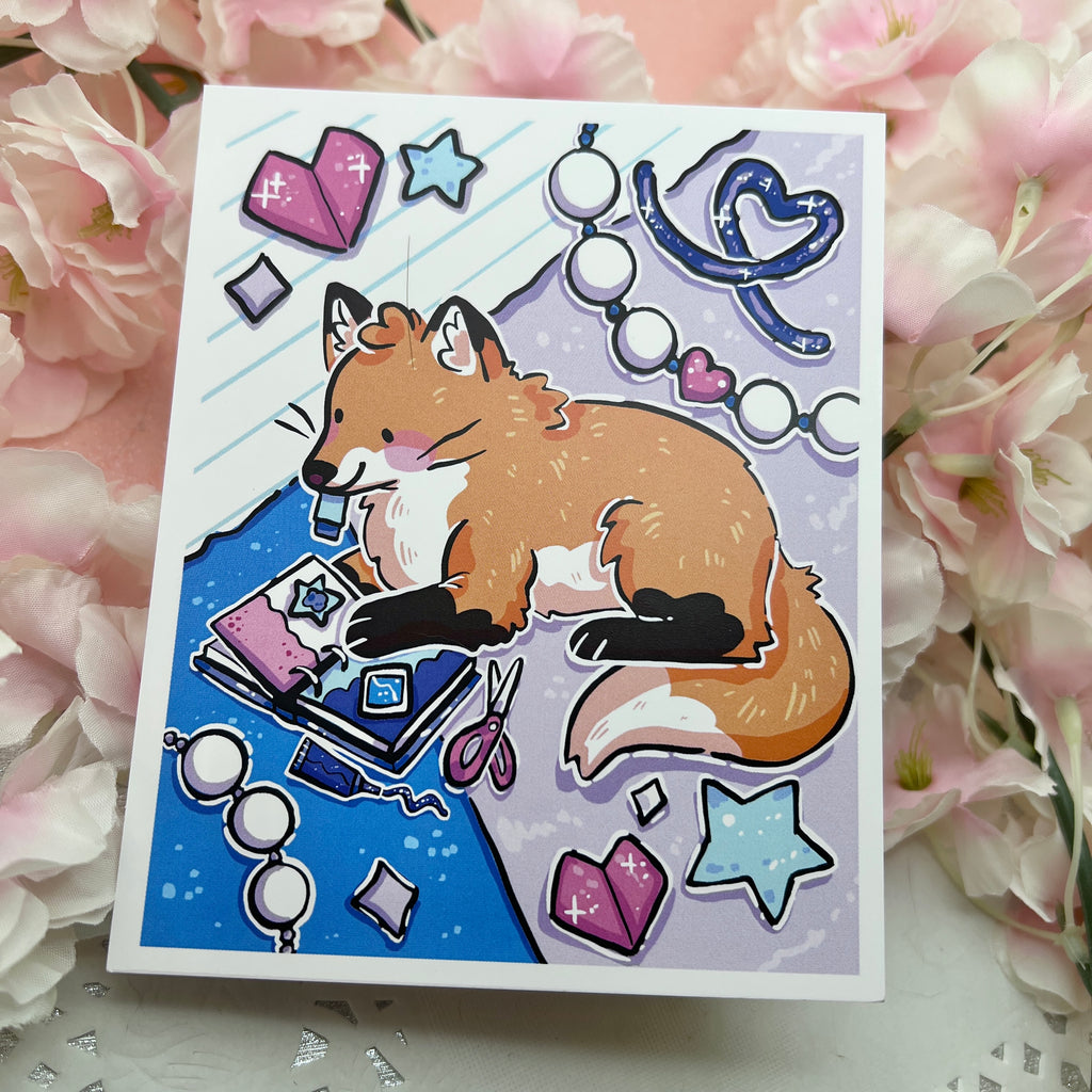 A print of a cute red fox scrapbooking away