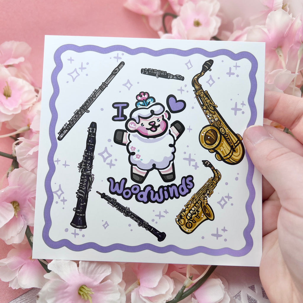 a print of a sheep with the text "I heart woodwinds" and six instruments floating around them (flute, piccolo, tenor sax, alto sax, oboe, clarinet)