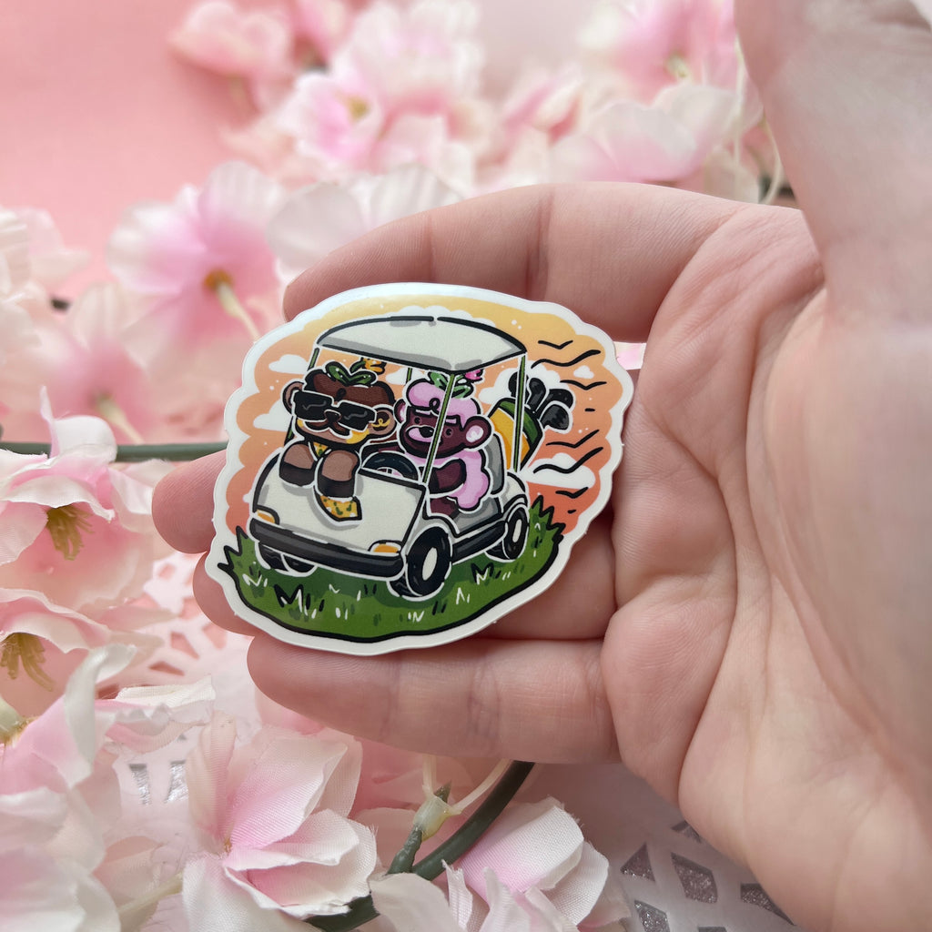 a sticker of a brown sheep with a mustache and a tie in a golf cart with a pink mustache sheep driving, a sunset behind them