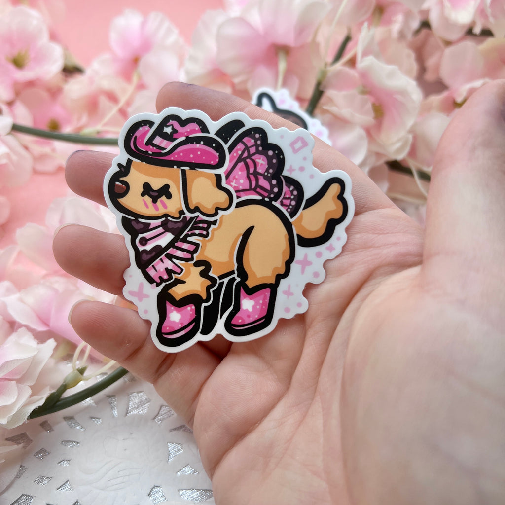  a sticker of a golden retreiver with a pink cowgirl hat, boots, and dark pink fairy wings.