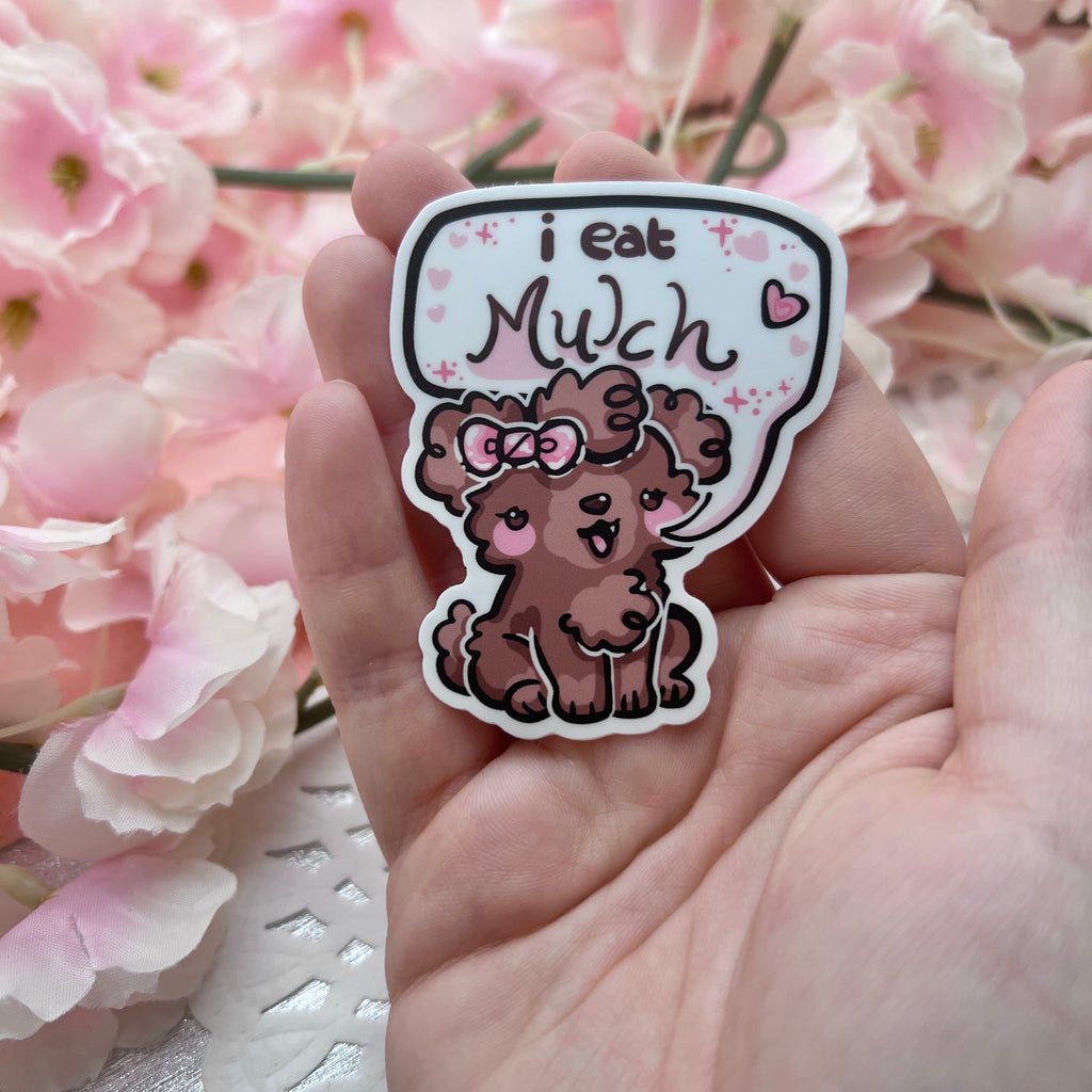 A sticker of a brown puppy with a pink bow that has a text bubble which says “I eat mulch”