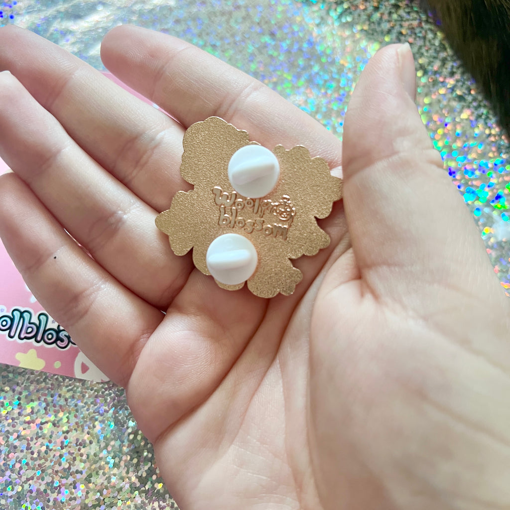 Showing the backstamp held in a hand against a glittery background