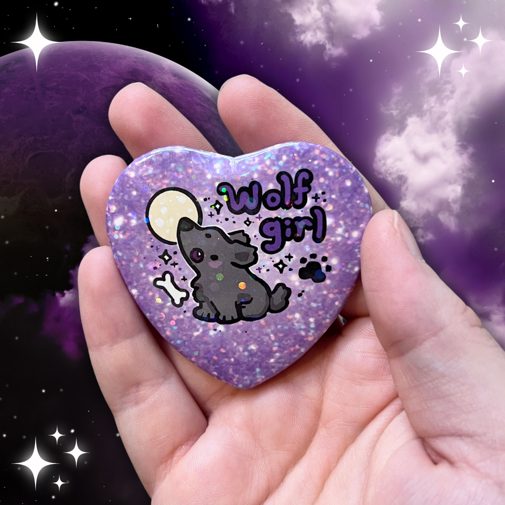 a heart button that says wolf girl with a grey wolf howling in front of a moon, the background of the button is purple glitter