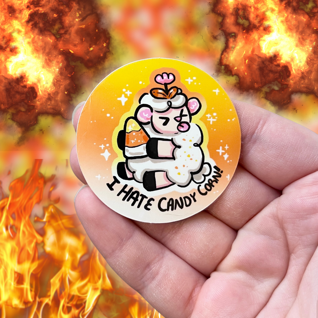 A sticker of a sheep holding a candy corn, sticking its tongue out, with the text "I hate candy corn!"